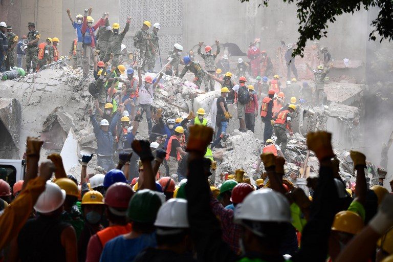 SEARCH AND RESCUE. Rescuers make the signal for silence during the search for survivors in a flattened building in Mexico City on September 21, 2017, two days after a strong quake hit central Mexico killing at least 240 people. Photo by Ronaldo Schemidt/AFP   