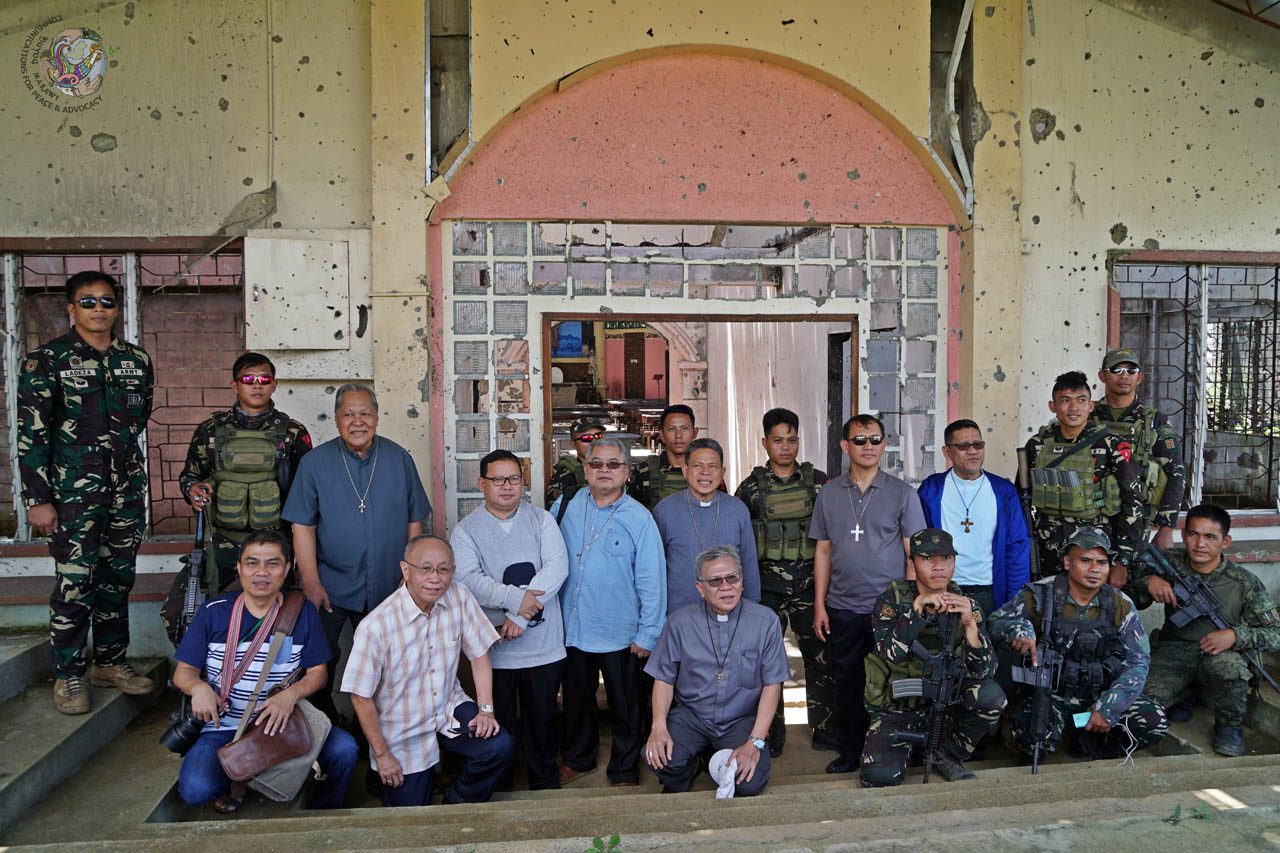 MILITARY ESCORT. Marawi Bishop Edwin de la Peña hopes to return again before the scheduled demolition of the church in June. Photo courtesy of DUYOG MARAWI  