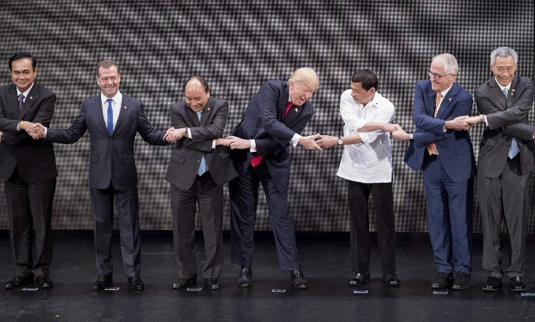 BETTER. (L-R) Thailand's Prime Minister Prayut Chan-O-Cha, Russian Prime Minister Dmitry Medvedev, Vietnam's Prime Minister Nguyen Xuan Phuc, US President Donald Trump, Philippine President Rodrigo Duterte, Australia Prime Minister Malcolm Turnbull and Singapore's Prime Minister Lee Hsien Loong join hands for the family photo during the 31st Association of South East Asian Nations (ASEAN) Summit in Manila on November 13, 2017. Jim Watson/AFP 