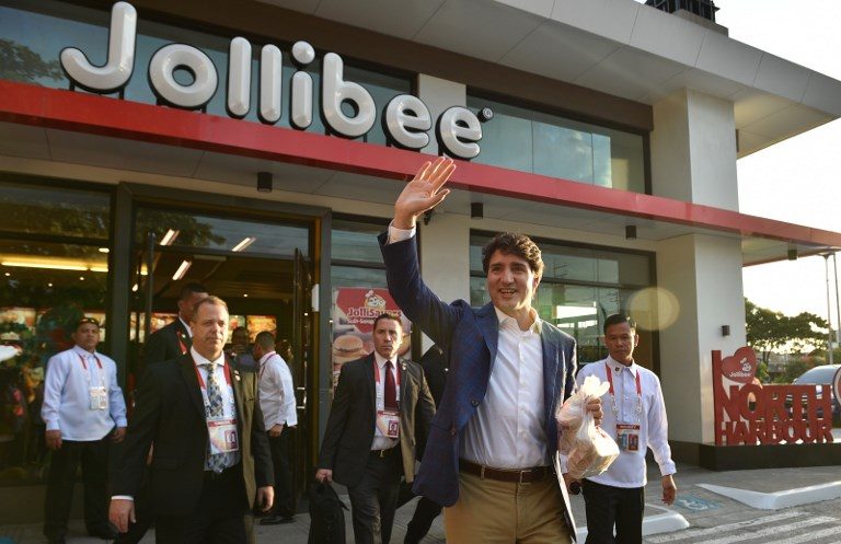 PIT STOP. Canadian Prime Minister Justin Trudeau (C) waves after visiting a branch of Filipino fast food chain Jollibee in Manila on November 12, 2017. Photo by Ted Aljibe/AFP 