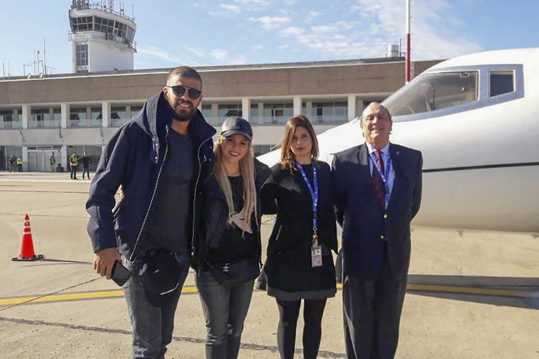 Pesepakbola Gerard Pique dan istrinya sekaligus artis Shakira tiba di bandara Rosario. Foto dari AEROPUERTO ROSARIO / AFP 