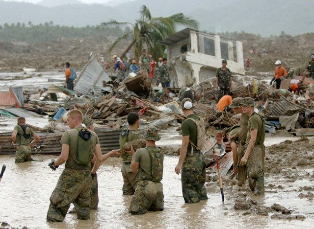 GUINSAUGON. US Marines struggle through mud to look for survivors buried under the Guinsaugon mudslide. File photo by Jay Directo/AFP 