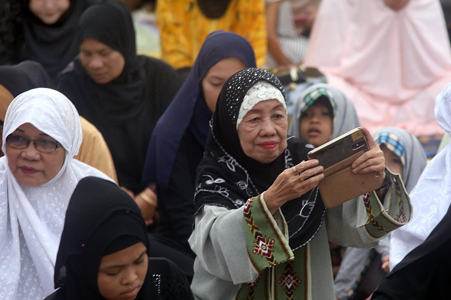 CAPTURING THE MOMENT? A woman uses her cellphone during the Eid'l Adha celebration on August 21, 2018. Photo by Darren Langit/Rappler  
