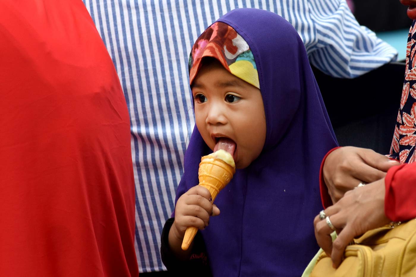 FEAST. A child licks her ice cream during the celebration of Eid'l Adha at the Quezon Memorial Circle on August 21, 2018. Photo by Angie de Silva/Rappler  