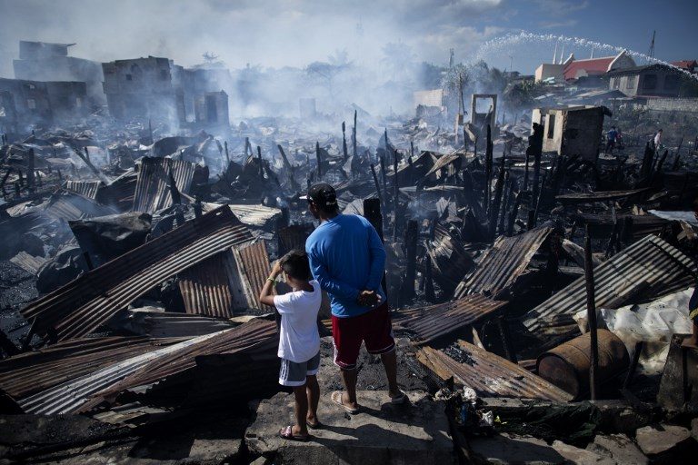HOMELESS. Residents look at destroyed houses after a fire engulfed a slum area in Navotas along Manila Bay on November 8, 2018.  Photo by Noel Celis/AFP  