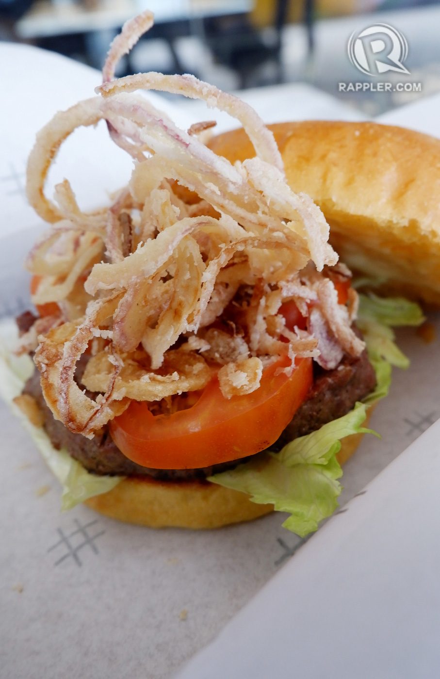 SIGNATURE DISH. The Todd English Burger with crispy onions on a house ground beef patty, served with T.E. sauce. 