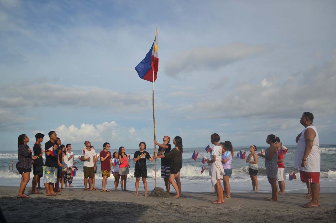 DAYBREAK. Dakila proudly sings the Philippine national anthem along the shores of Zambales fronting the West Philippine Sea. Photo by Charlon Kim 