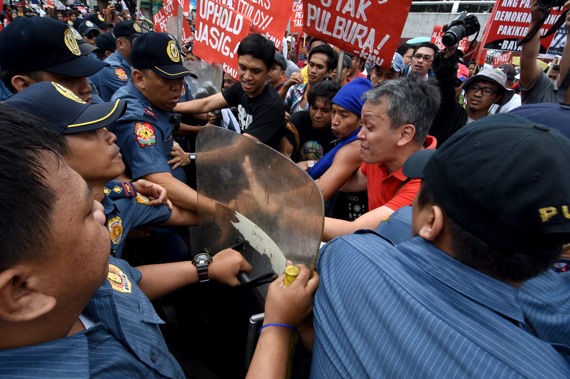 ENTER THE CAMP. Activists try to enter the gate of Camp Aguinaldo but are stopped by anti-riot policemen. Photo by Angie de Silva/Rappler  