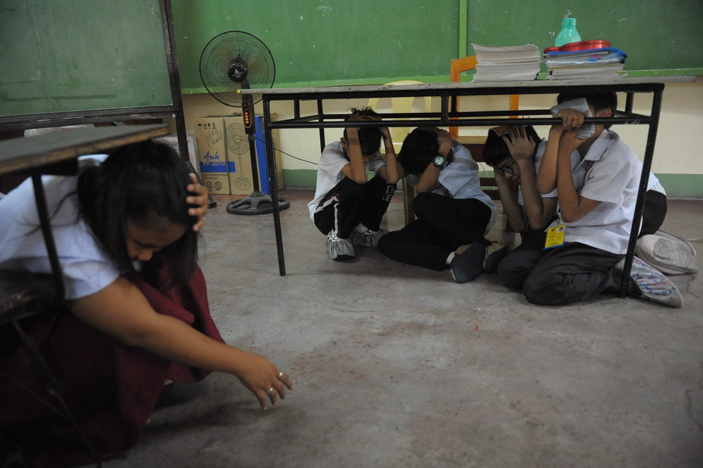 DUCK. Students participate on the 4th Metro Manila simultaneous Earthquake drill in Artaullo High School , Manila.
Photo by Inoue Jaena/Rappler 