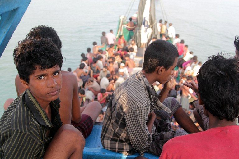 ARRIVAL BY BOAT. Rohingya migrants sit in a boat as they're towed closer to land by fishermen, off the coast of Aceh province. Januar/AFP  