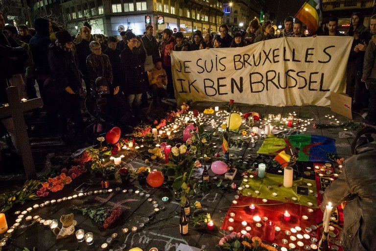 TRIBUTES. People hold a banner reading in French and Flamish 'I AM BRUSSELS' as they gather around floral tributes, candles, Belgian and peace flags and notes in front of the Bourse of Brussels on March 22, 2016 in tribute to the victims of Brussels following triple bomb attacks in the Belgian capital that killed about 35 people and left more than 200 people wounded. Aurore Belot/Belga/AFP 
