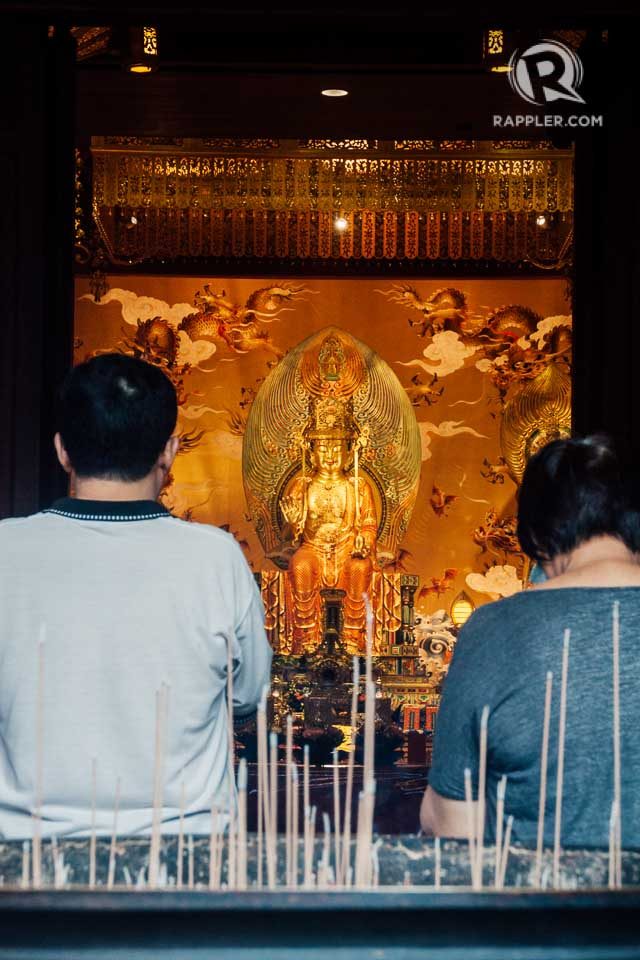 DEVOTION. Locals devotees offer prayers at the Buddha Tooth Relic Temple in Chinatown. 
