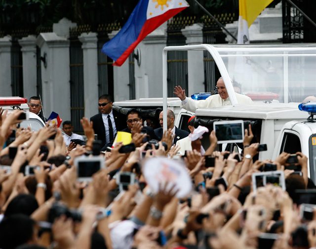 Pope Francis on a popemobile waves to well wishers at a street following his meeting at the Malacanang Palace in Manila on January 16. 2015. Photo by Dennis Sabangan/EPA