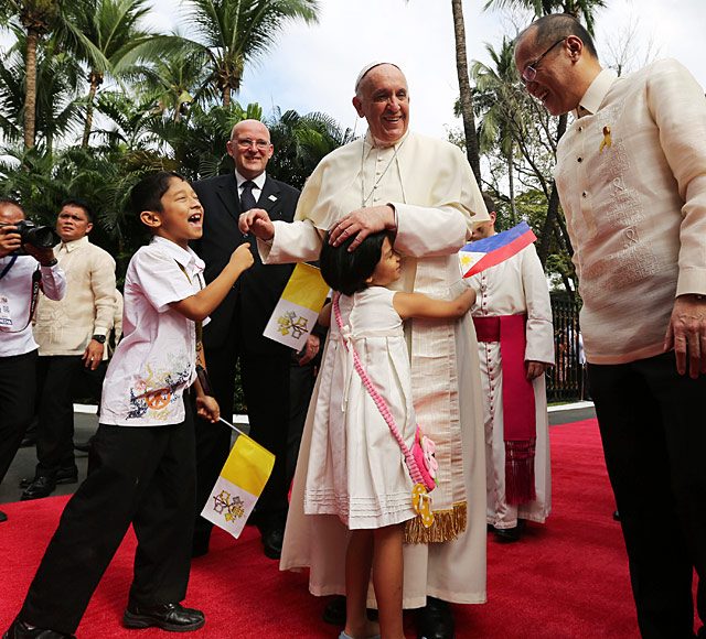 Pope Francis accompanied by President Benigno S. Aquino hugs children during a ceremony at the Malacanang Palace. Photo by Robert Vinas/ Malacanang Photo Bureau
