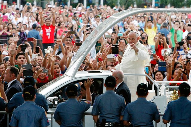Pope Francis waves to Filipino well wishers from his popemobile on his way to the meeting with Filipino families at MOA Arena on January 16, 2015. Photo by Dennis Sabangan/EPA