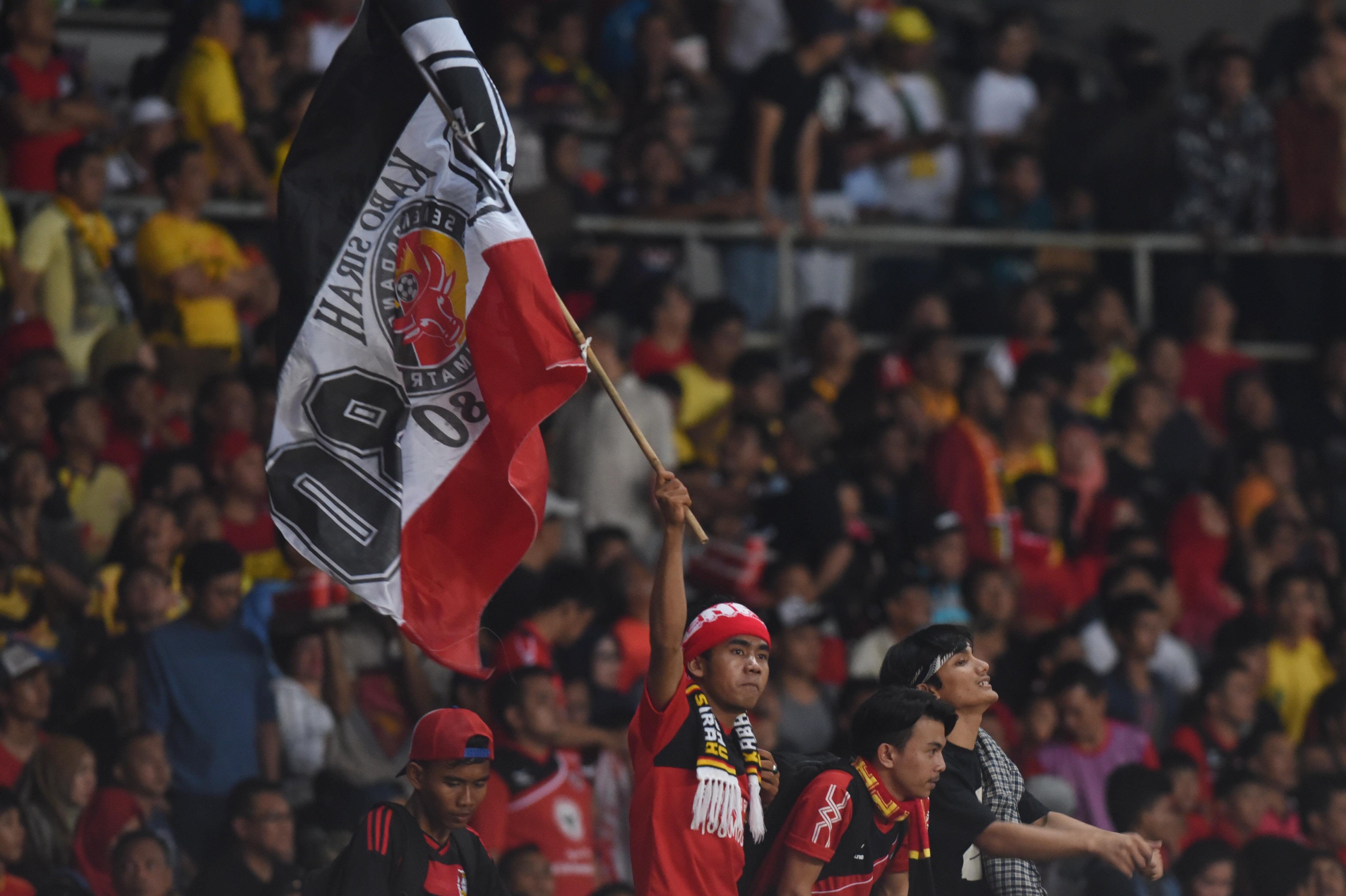 Suporter tim Semen Padang mengibarkan bendera klubnya. Foto oleh Akbar Nugroho Guma/Antara 