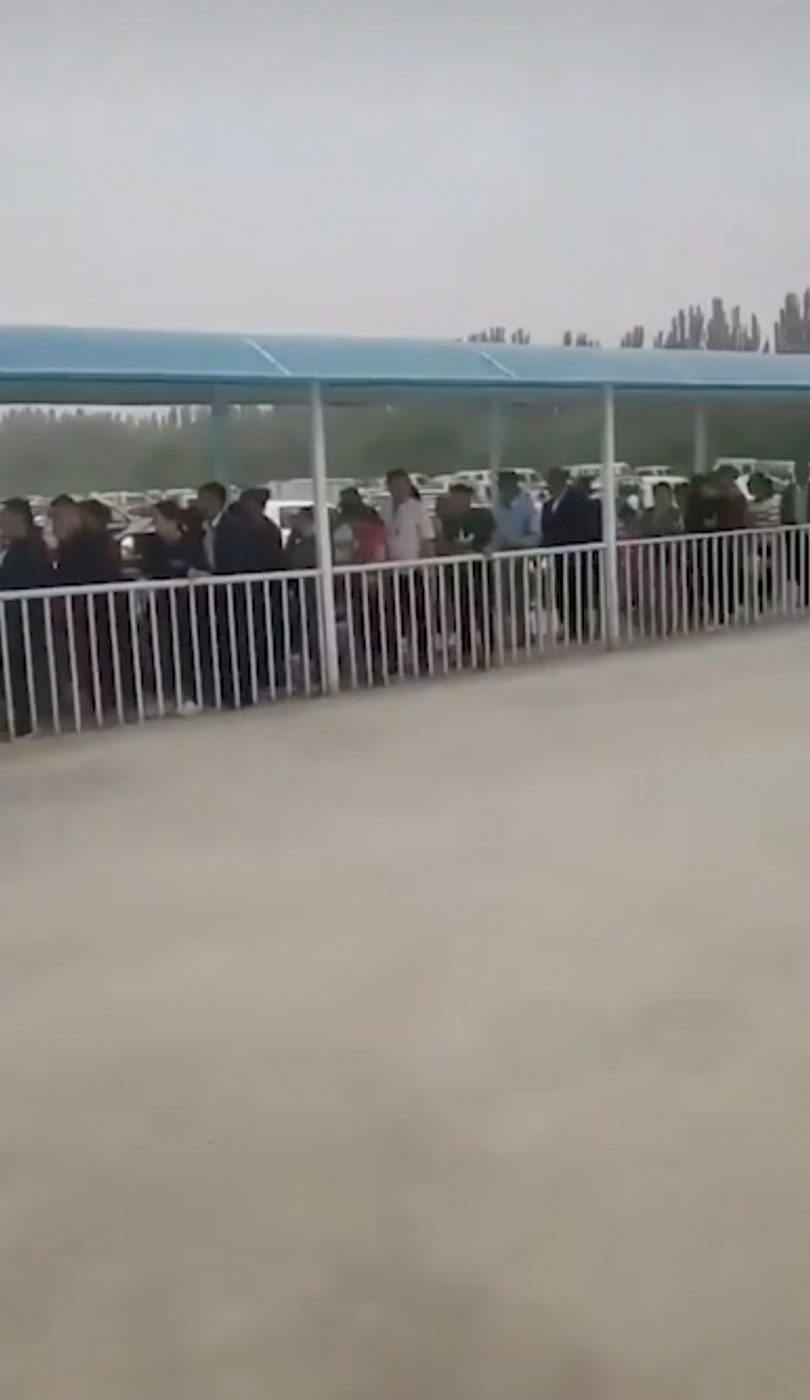 CHECKPOINT. Screenshot of a video appearing to show a long line of Uyghurs waiting to be scanned at a checkpoint in Xinjiang. 