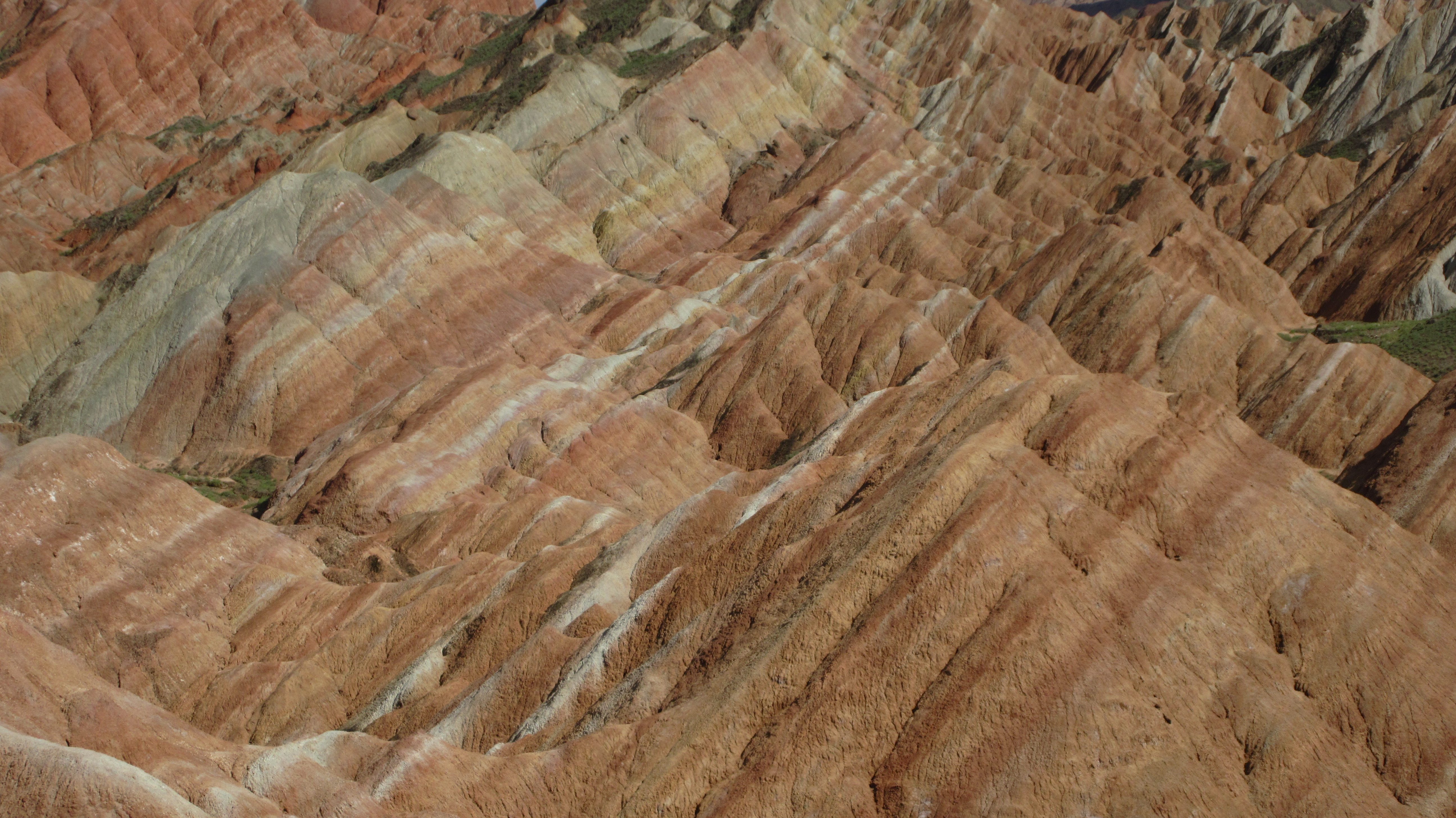 RAINBOW STRIPS. The mountains are lined with multiple colors, creating a rainbow-like surface.
 