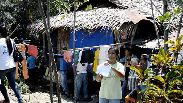 A Subanen shows a resolution issued by the National Commission on Indigenous Peoples directing the city government of Dipolog not to demolish the IP's houses. Photo by Gualberto Laput/Rappler  