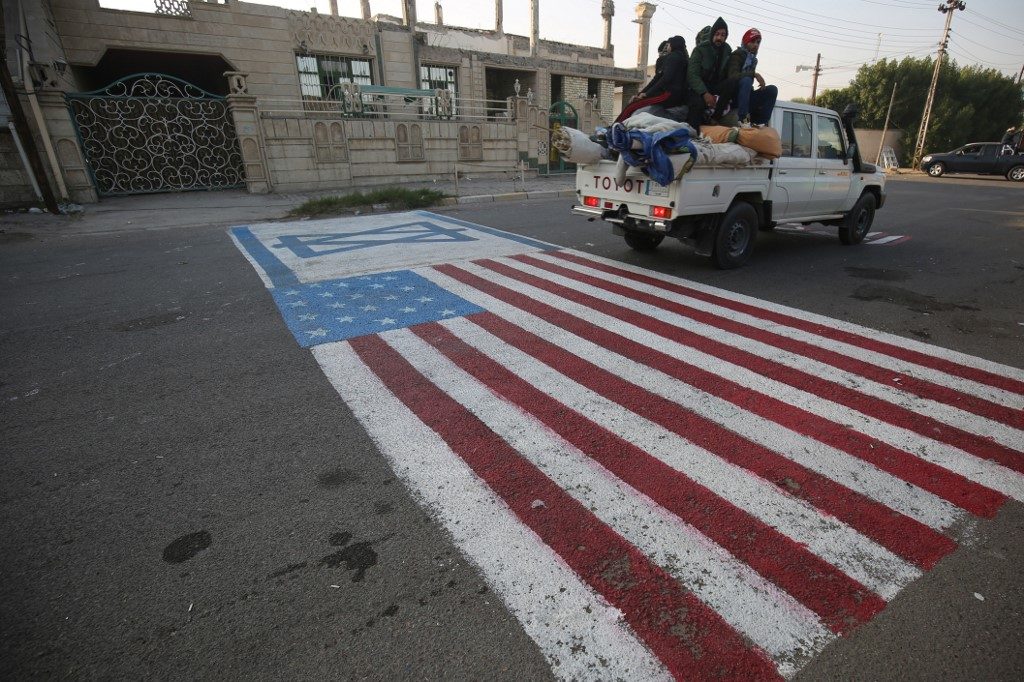 WORLD REACTS. A mock US flag is painted on the ground for cars to drive on in the Iraqi capital Baghdad on January 3, 2020, following news of the killing of Iranian Revolutionary Guards top commander Qasem Soleimani in a US strike on his convoy at Baghdad international airport. Photo by Ahmad Al-Rubaye/AFP 