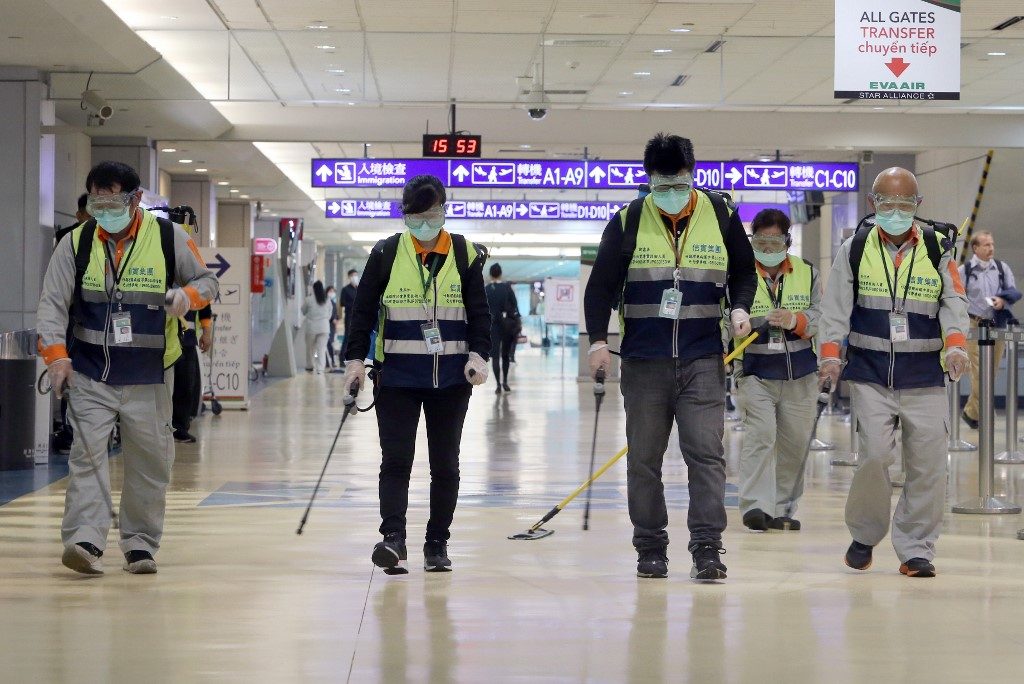 PREVENTION. Masked workers disinfect a passenger throughfare at the Taoyuan International Airport on January 22, 2020 after Taiwan reported its first case of the novel coronavirus. Photo by Chen Chi-chuan/AFP 