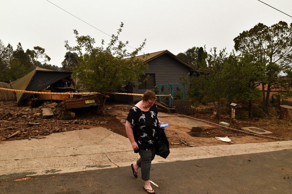 DISASTER. A resident walks away from her flood-damaged house in the bushfire-affected town of Cooma on January 5, 2020. Photo by Saeed Khan/AFP 