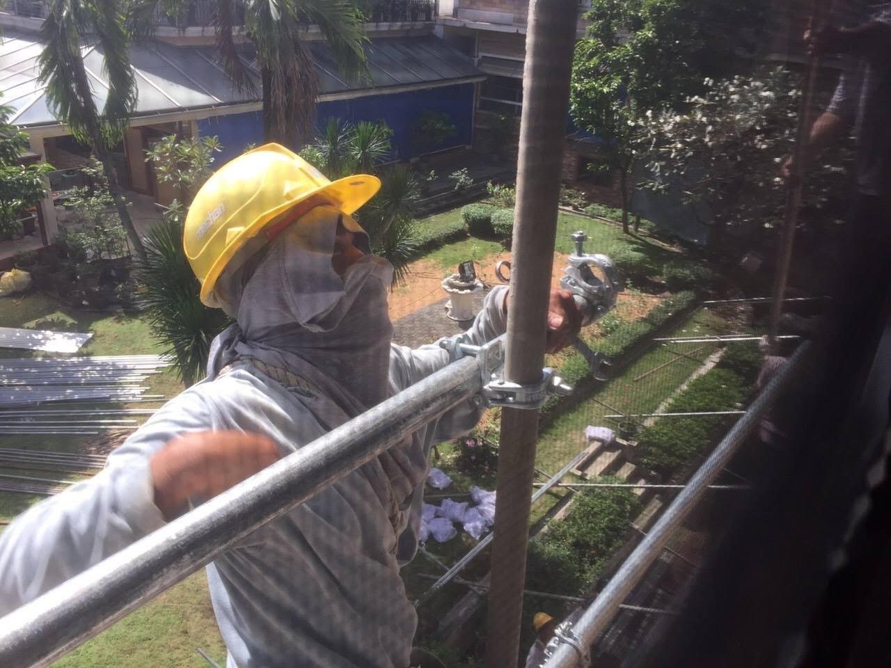 ONGOING CONSTRUCTION. A construction worker working in the compound puts up fences around the house of Angel Manalo. Photo sourced by Rappler    