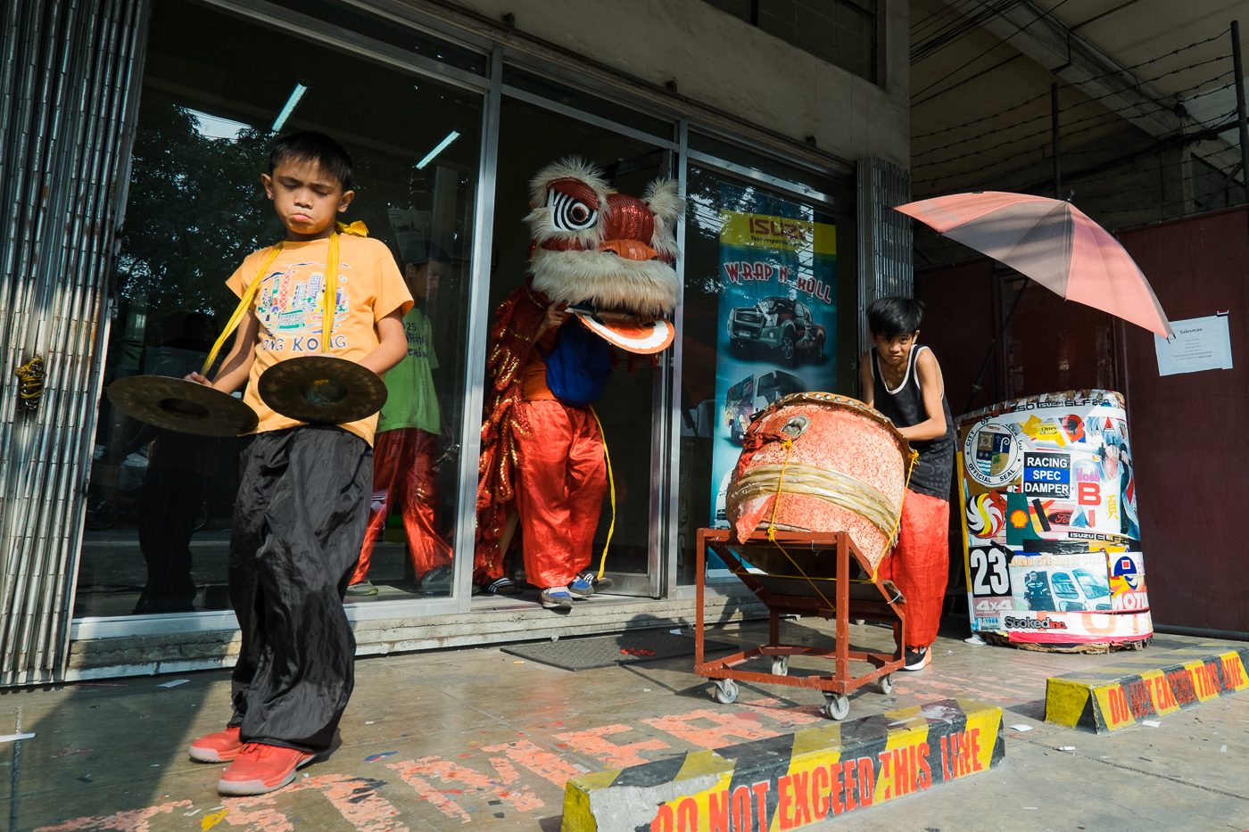 Young dragon dancers exit a car shop in Banawe, Quezon City after peforming days before Chinese New Year. 