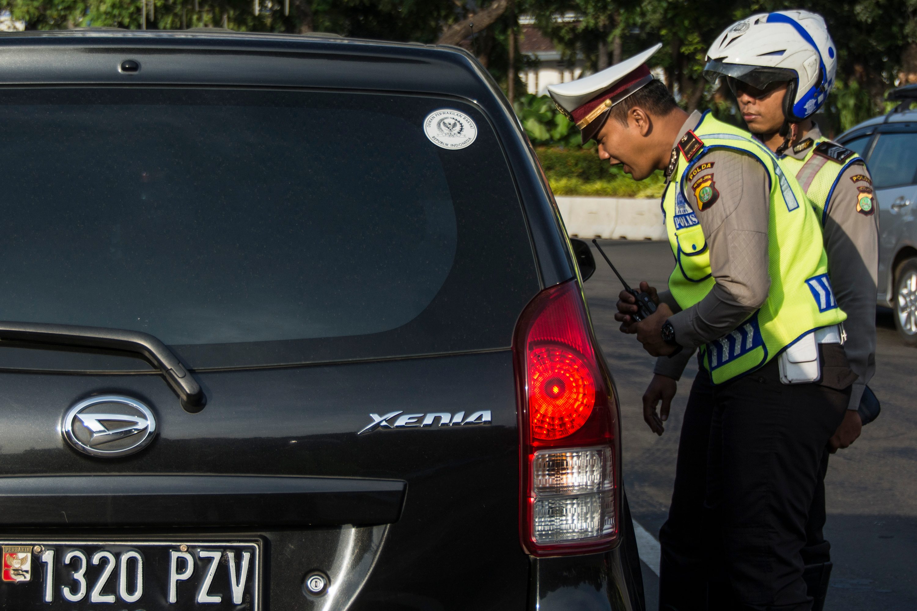 Polisi Lalu Lintas Polda Metro Jaya memberikan imbauan kepada pengendara yang kendaraannya berpelat nomor genap saat uji coba penerapan sistem lalu lintas plat Ganjil Genap di Jalan Medan Merdeka Barat, Jakarta, pada 27 Juli 2016. Foto oleh Aprillio Akbar/Antara 