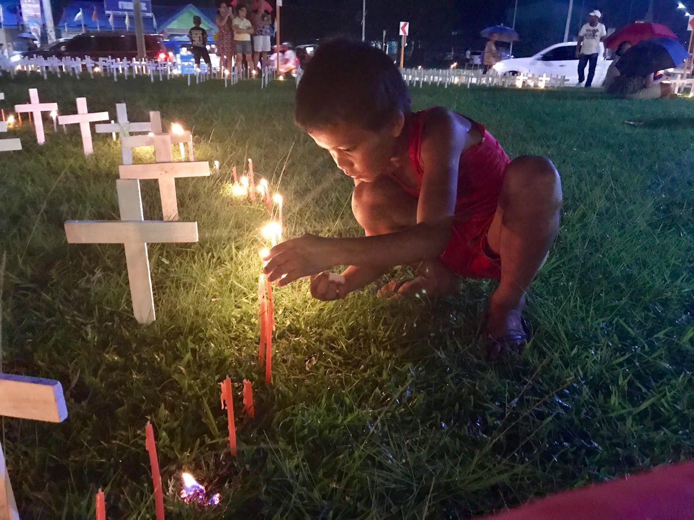 REMEMBERING. A child lights a candle to remember those who died during the disaster. Photo by Jene-Anne Pangue  