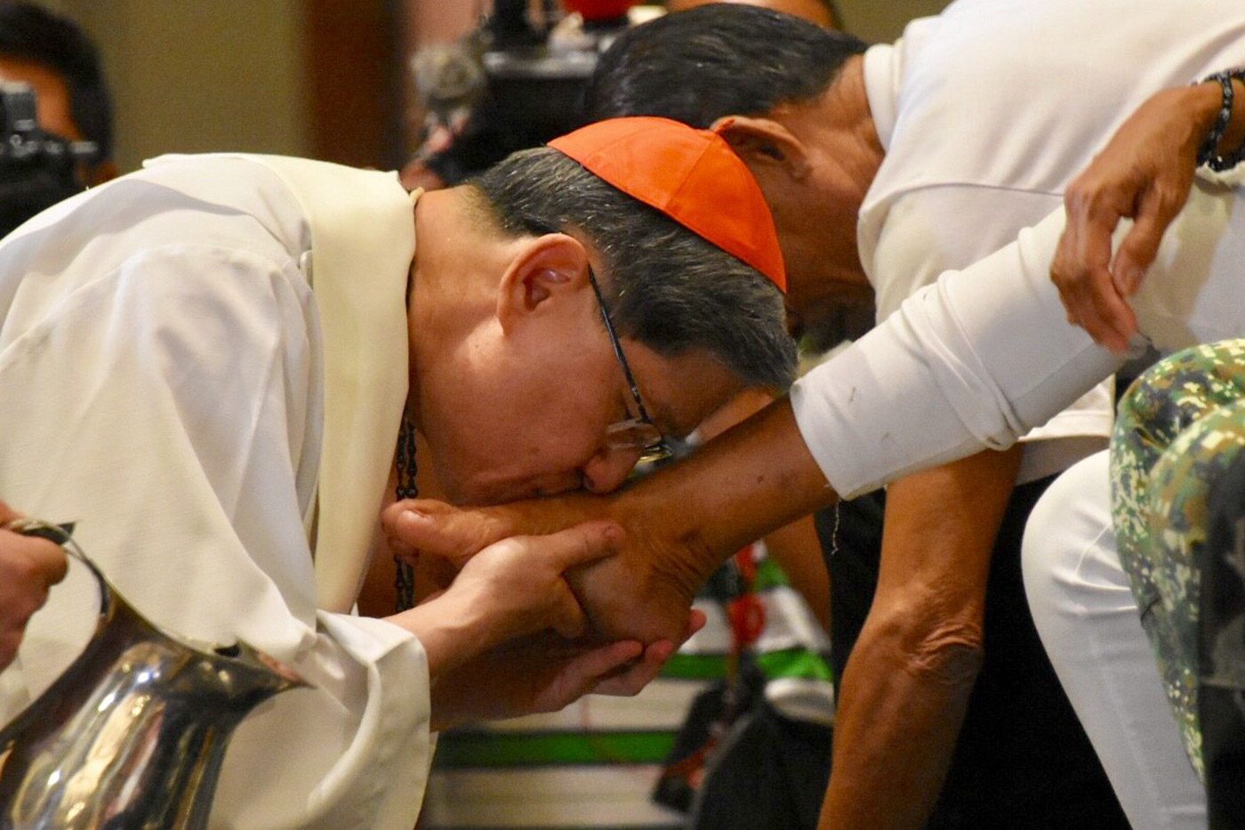 MAUNDY THURSDAY. Manila Archbishop Luis Antonio Cardinal Tagle washes and kisses the feet of 12 individuals representing migrants, refugees, and displaced people during the traditional Washing of the Feet on Maundy Thursday, March 29, 2018. Photo by Angie de Silva/Rappler   