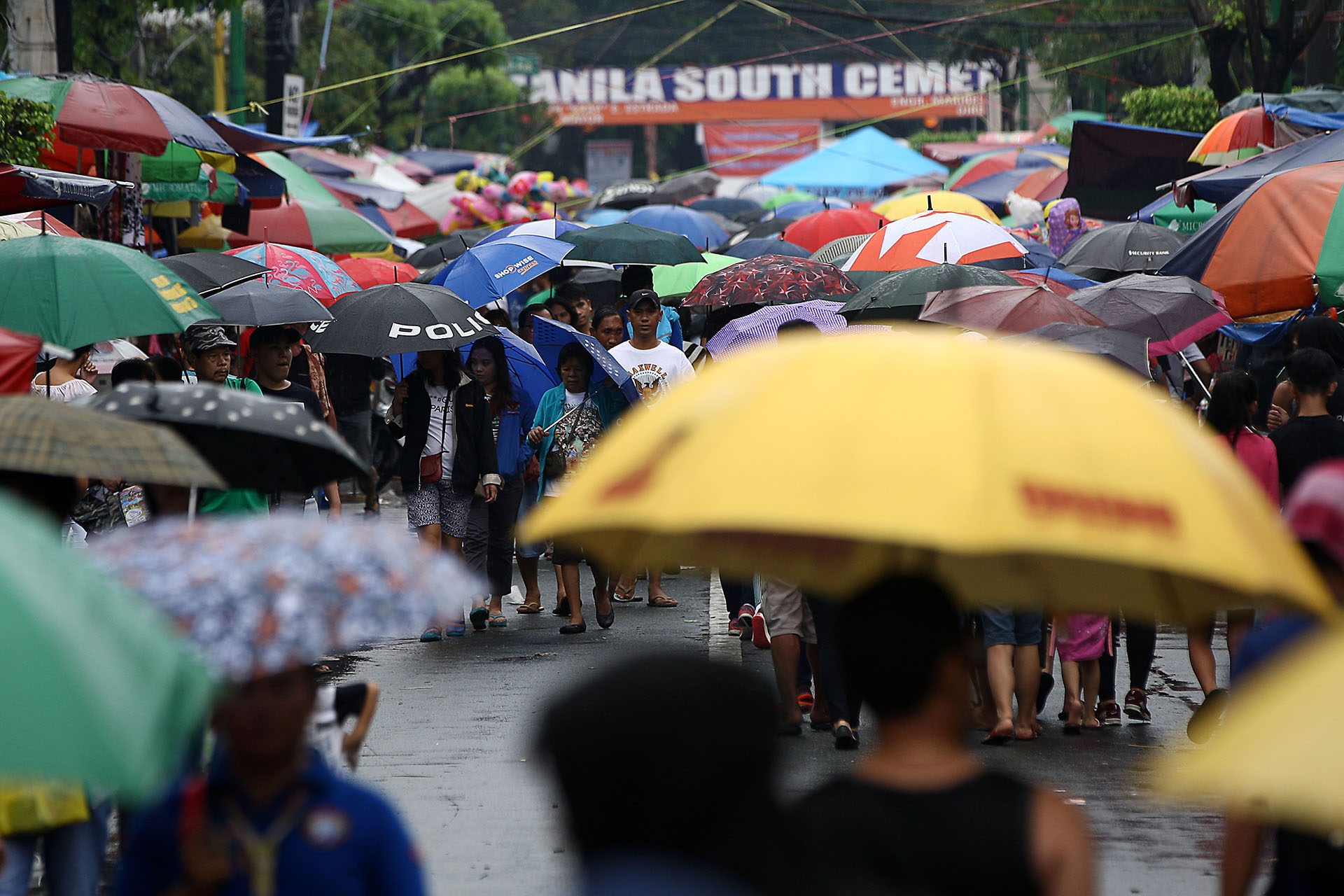 VISITORS brave the rains brought about by a tropical depression, and still flock to the Manila South Cemetery in Makati City on November 1, 2017. Photo by Ben Nabong/Rappler
 