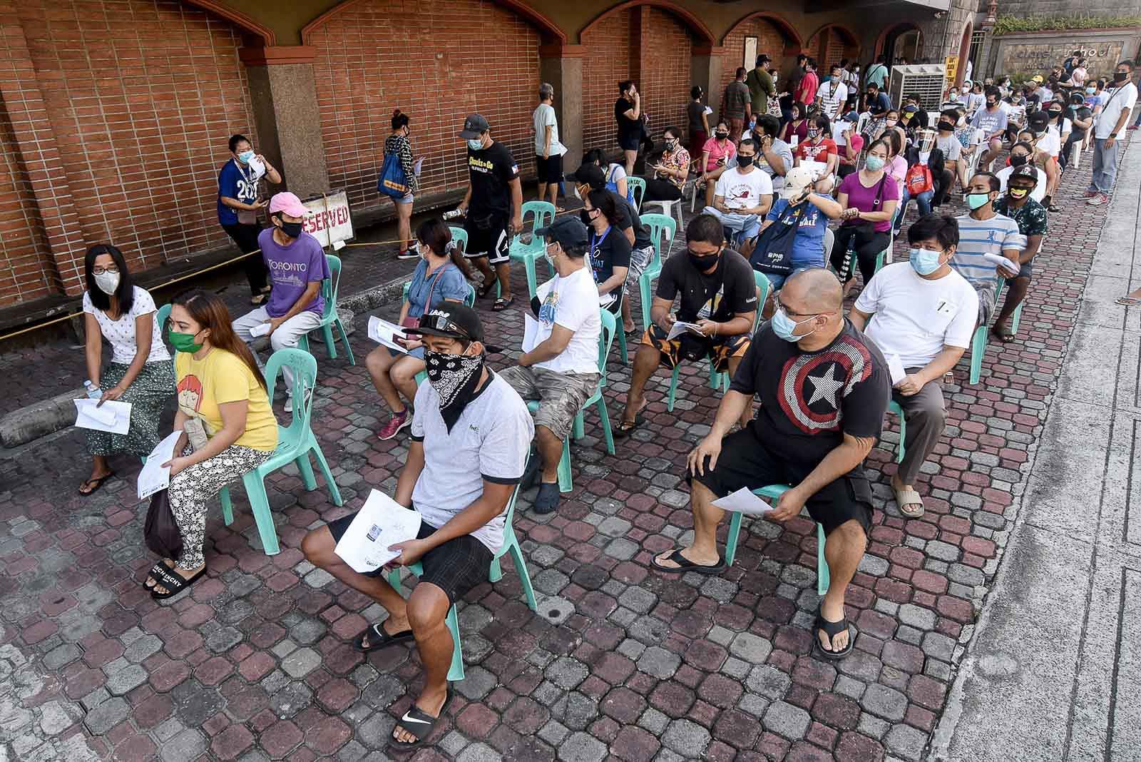 WAITING. Residents of Teachers Village East in Quezon City queue for the government's emergency subsidy program on May 2, 2020. Photo by Angie de Silva/Rappler 