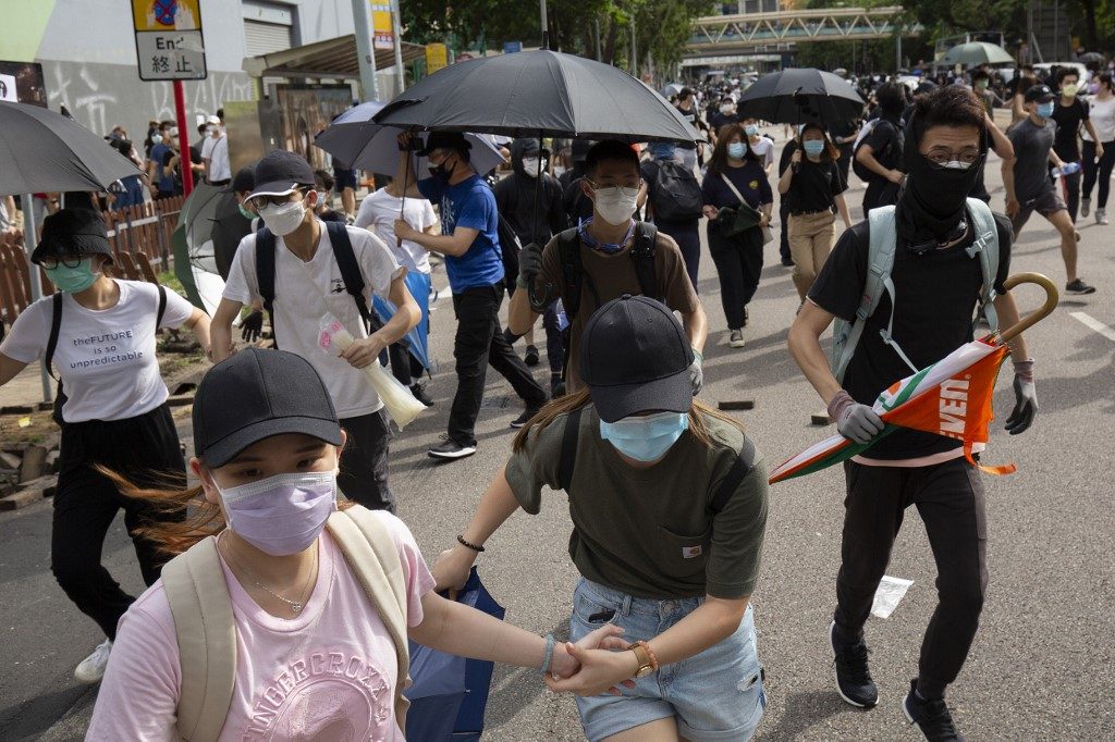 RUN. Protesters occupying a road run after hearing police are approaching during a rally against a new national security law in Hong Kong on July 1, 2020, on the 23rd anniversary of the city's handover from Britain to China. Photo by Alastair Pike/AFP 