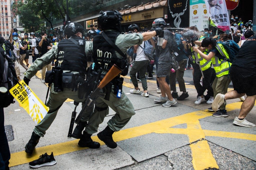 PROTESTS. Riot police (L) deploy pepper spray toward journalists (R) as protesters gathered for a rally against a new national security law in Hong Kong on July 1, 2020, on the 23rd anniversary of the city's handover from Britain to China. Photo by Dale De La Rey/AFP 