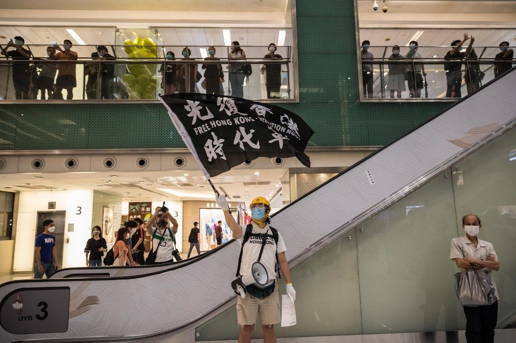 DEMONSTRATION. A protester holds a flag that reads 'Free Hong Kong - Revolution Now' as he attends a pro-democracy rally at a shopping mall in Hong Kong on June 12, 2020. Photo by Dale de la Rey/AFP 