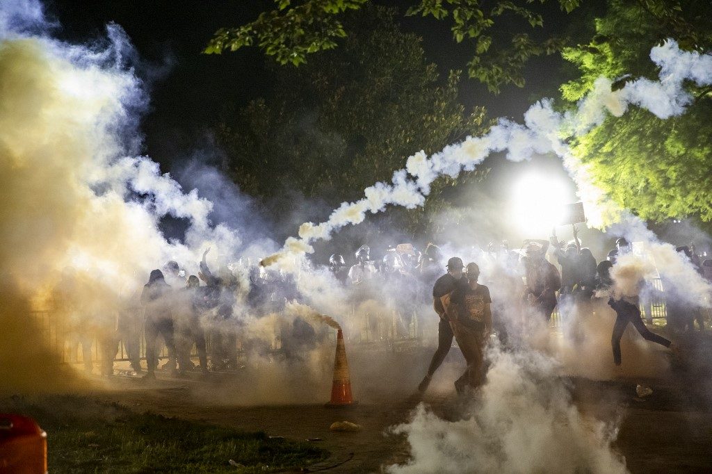 FACING OFF. Tear gas rises above as protesters face off with police during a demonstration outside the White House over the death of George Floyd at the hands of Minneapolis Police. Photo by Samuel Corum/AFP 