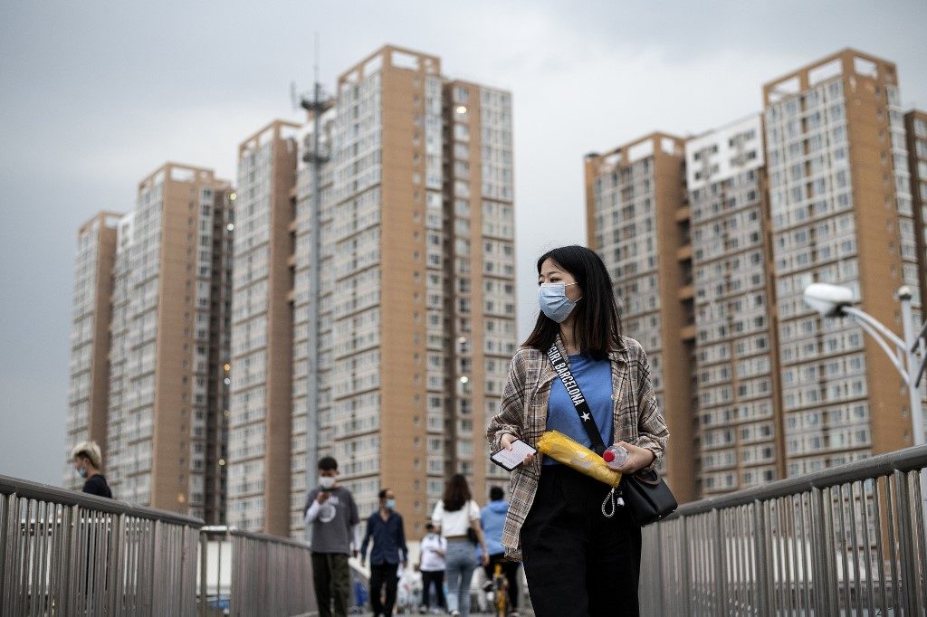 NO NEW INFECTIONS. People wearing face masks walk on an overpass in Beijing on June 1, 2020. Photo by Noel CELIS/AFP 