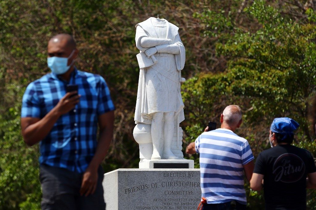 HEADLESS. People photograph a statue depicting Christopher Columbus which had its head removed at Christopher Columbus Waterfront Park on June 10, 2020 in Boston, Massachusetts. Photo by Tim Bradbury/Getty Images/AFP 