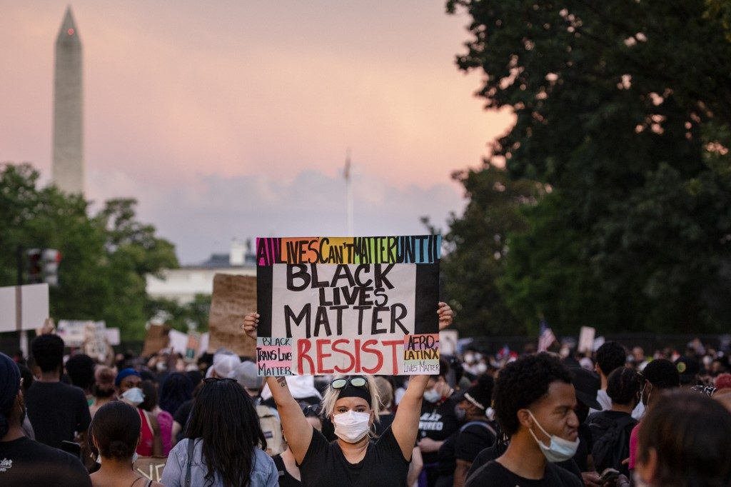 UNREST. A protester holds up a sign on the recently renamed Black Lives Matter Plaza near the White House as the sun sets during continued demonstrations on June 6, 2020 in Washington, DC. Photo by Samuel Corum/Getty Images/AFP 
