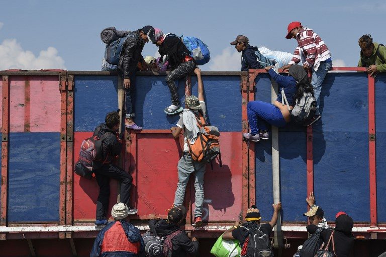 HITCH HIKE. Central American migrants – mostly Hondurans – taking part in a caravan to the US, get on board a truck heading to Irapuato in Guanajuato on November 11, 2018 after spending the night in Queretaro, Mexico. Photo by Alfredo Estrella/AFP   