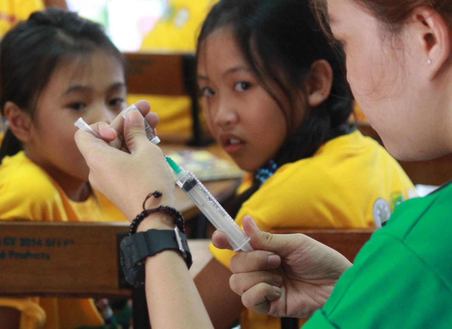ONE MILLION STUDENTS. Students from Parang Elementary School look on as a health worker prepares to administer a dengue vaccine on Monday, April 4. Photo by Joel Liporada/Rappler    