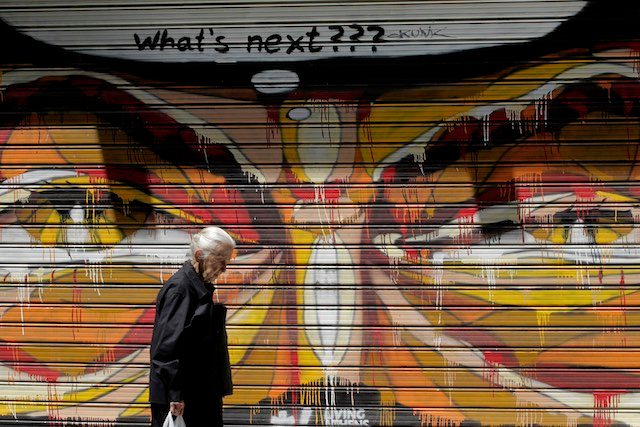'WHAT'S NEXT?' An elderly woman walks past a graffiti beneath a freshly-written 'What's next???' message in central Athens, on July 13, 2015. Orestis Panagiotou/EPA 