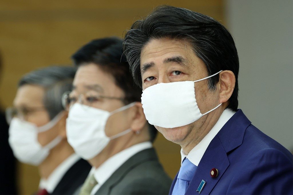 JAPAN. Japan's Prime Minister Shinzo Abe (R), wearing a face mask, attends a meeting of COVID-19 coronavirus task force in Tokyo on May 4, 2020. File photo by JIJI PRESS/AFP 