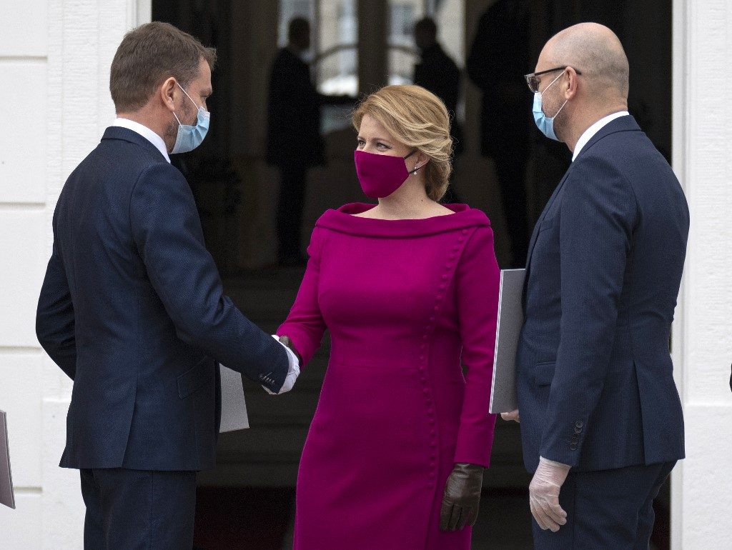 SLOVAKIA. Newly appointed Slovak Prime Minister Igor Matovic (L), leader of the OLaNO anti-graft party shakes hands with President Zuzana Caputova after a swearing in ceremony of the new four-party coalition government and before a family picture on March 21, 2020 outside of the Presidential palace in Bratislava. File photo by Joe Klamar/AFP 