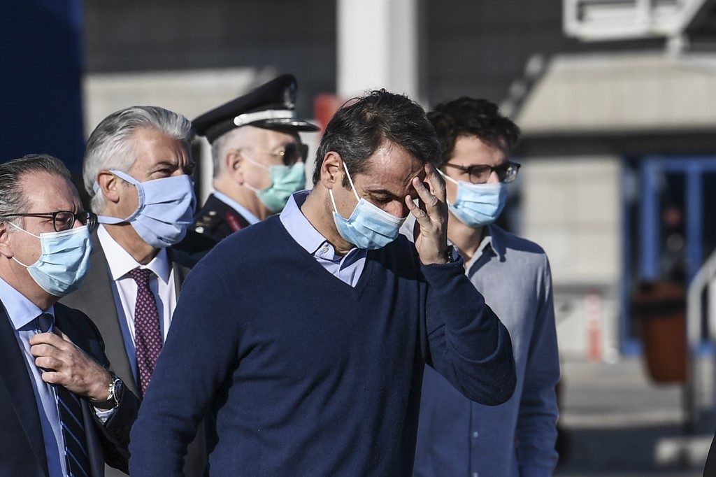 GREECE. Greek Prime Minister Kyriakos Mitsotakis (C) wearing a protective face mask, arrives to attend the departure of minor migrants who were living in camps on the Greek islands, at the International Airport of Athens, to travel on a special flight to Germany, on April 18, 2020. File photo by Aris Messinis/AFP 