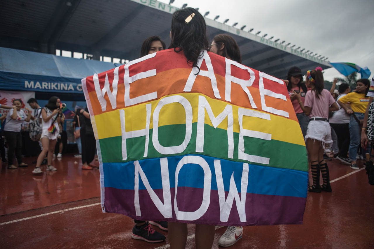 SAFE SPACE. A participant displays a Pride flag with words 'We are home now' during the Metro Manila Pride March at the Marikina Sports Center on Saturday, June 29. Photo by Rob Reyes/Rappler 