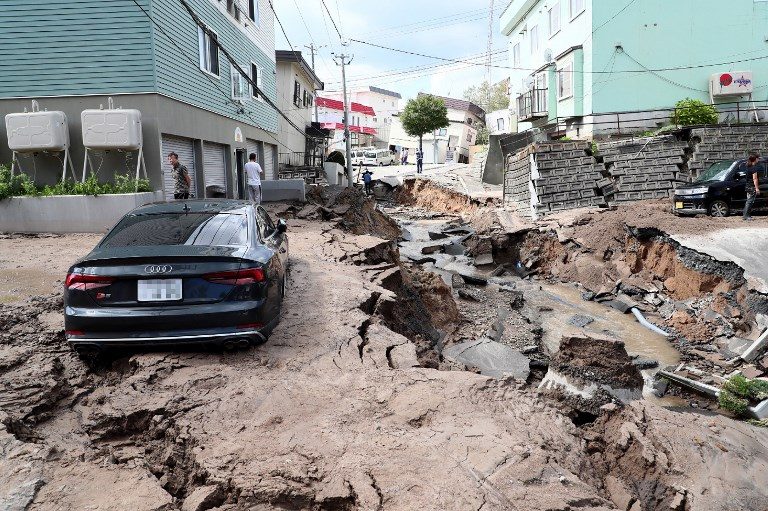 POWERFUL QUAKE. A car is seen stuck on a road damaged by an earthquake in Sapporo, Hokkaido prefecture on September 6, 2018. Photo by Jiji Press/AFP  