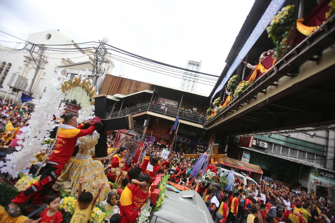 SHOWER. Priests stationed atop the footbridge near Quiapo Chruch shower holy water at the devotees and their Black Nazarene replicas. Photo by Ben Nabong/Rappler  