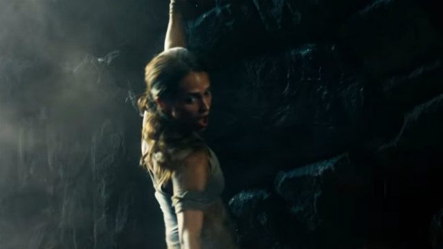DANGER. Lara hangs for her lift in a cliff. 